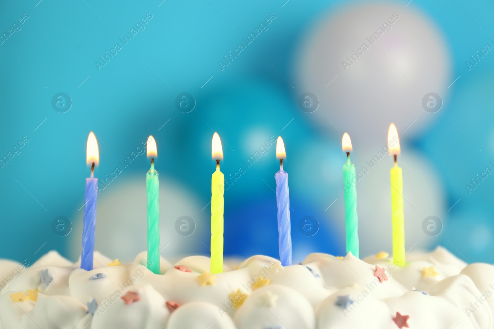 Photo of Birthday cake with burning candles on blurred background, closeup