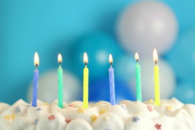 Birthday cake with burning candles on blurred background, closeup