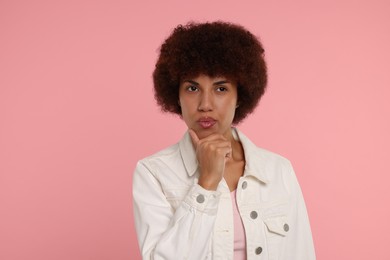 Photo of Portrait of thoughtful young woman on pink background