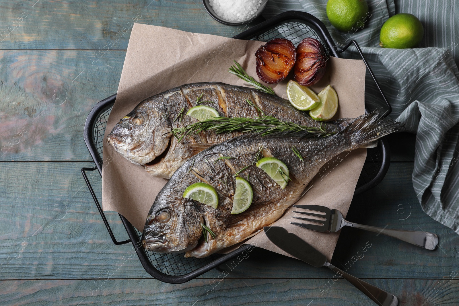 Photo of Delicious baked fish served on wooden rustic table, flat lay. Seafood