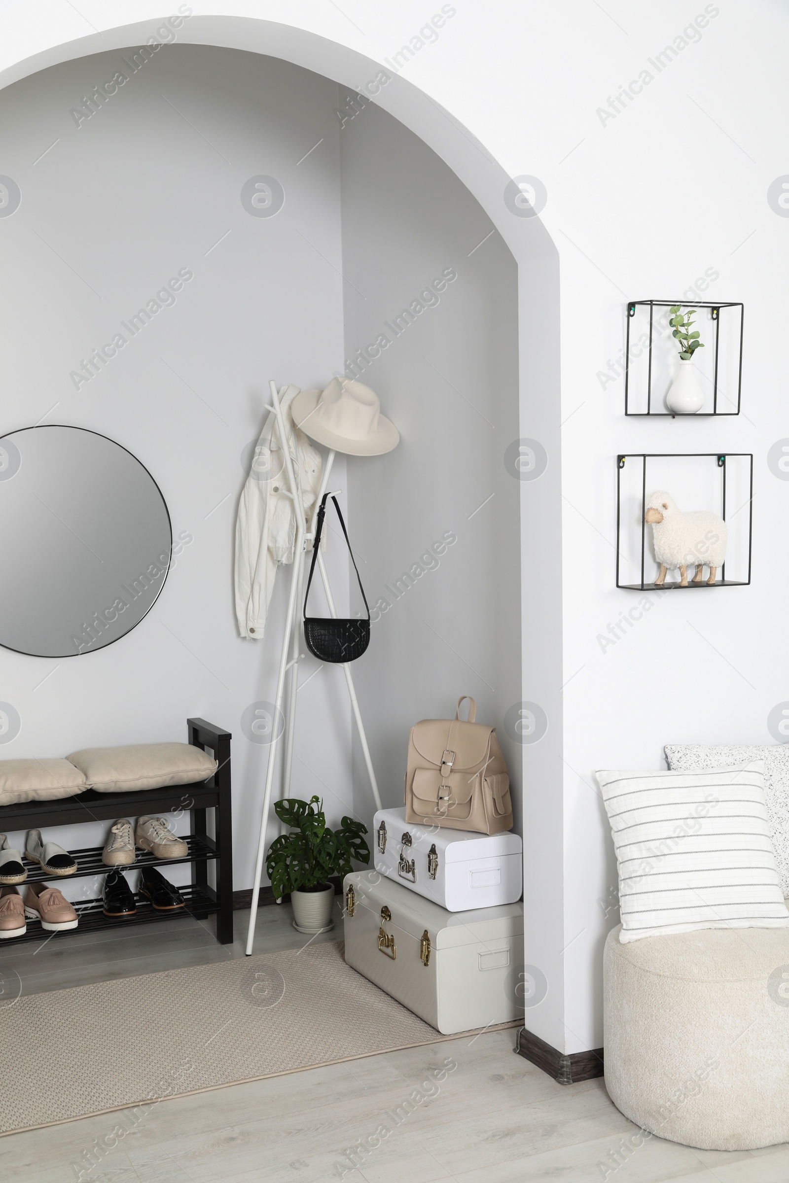 Photo of Hallway interior with stylish furniture and round mirror on light wall