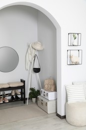 Photo of Hallway interior with stylish furniture and round mirror on light wall