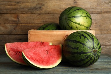 Photo of Delicious ripe whole and cut watermelons on wooden table