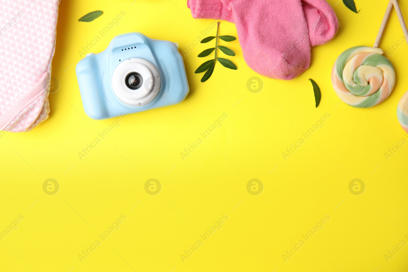 Photo of Flat lay composition with toy camera on yellow background, space for text. Future photographer