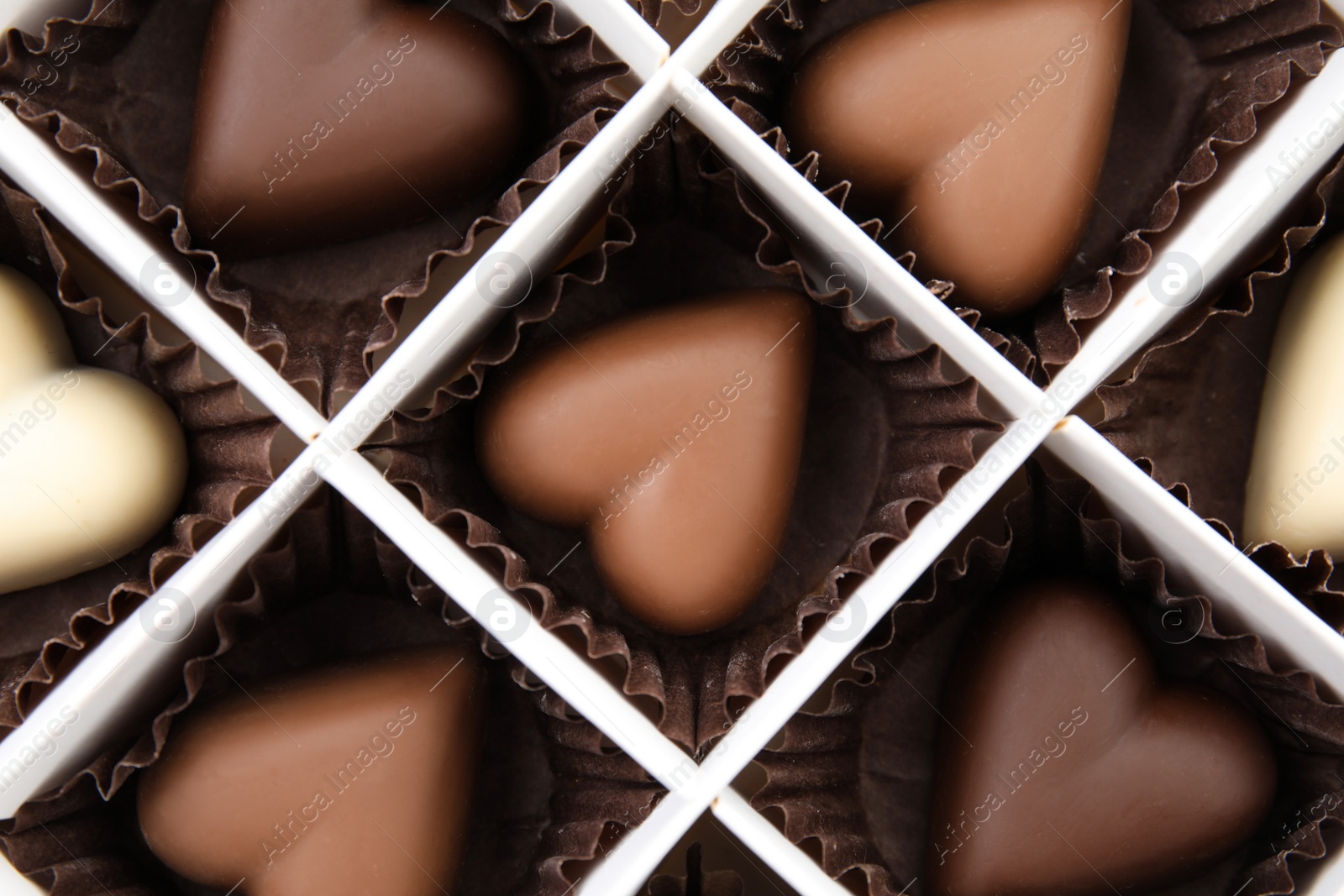 Photo of Tasty heart shaped chocolate candies in box, top view. Valentine's day celebration