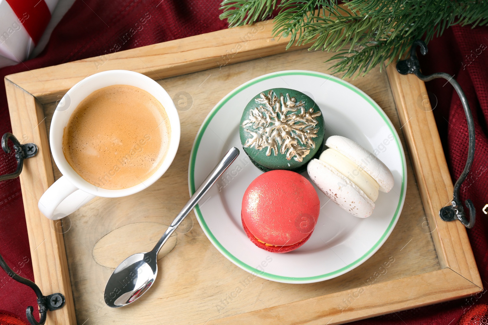 Photo of Different decorated Christmas macarons served with coffee on table, flat lay