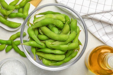 Photo of Green edamame beans in pods served on light grey table, flat lay