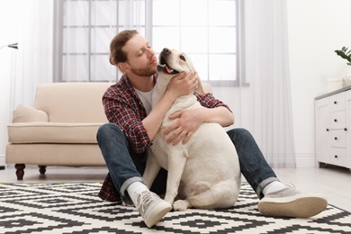 Photo of Adorable yellow labrador retriever with owner at home