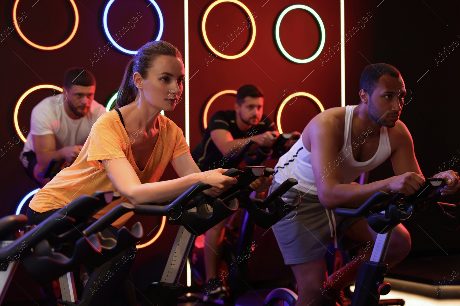 Photo of Group of people training on exercise bikes in fitness club