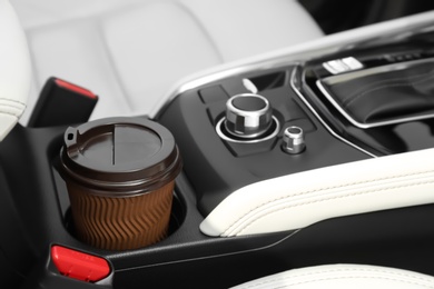 Photo of Takeaway paper coffee cup in holder inside car