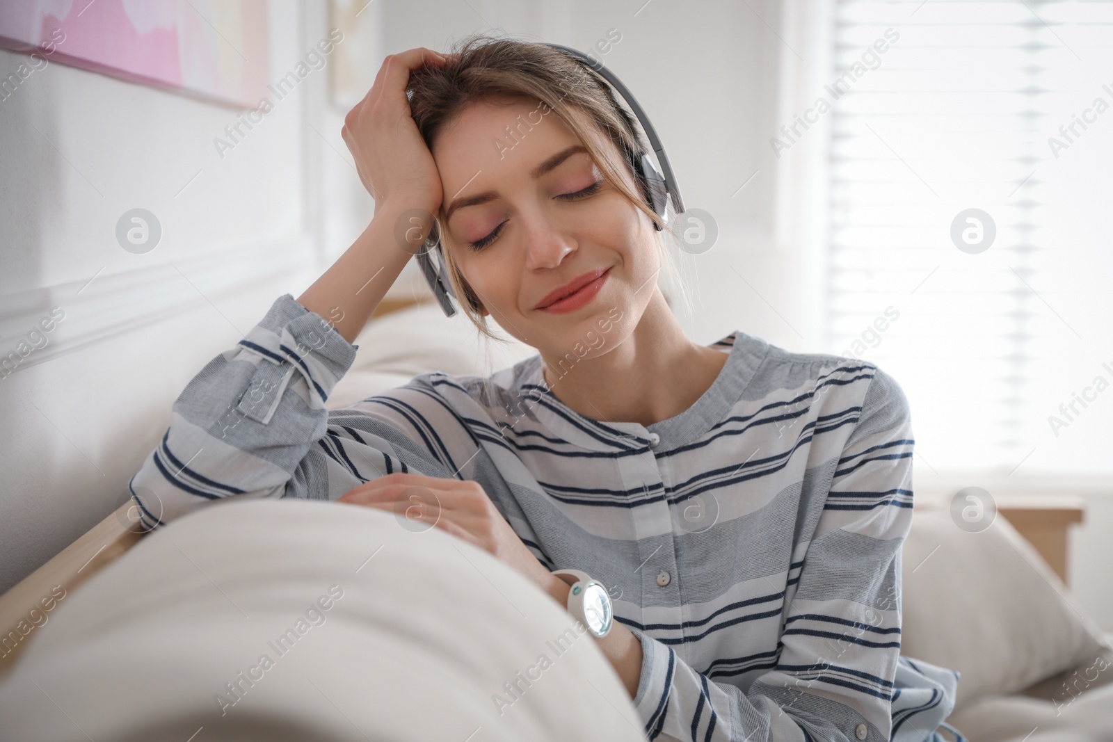 Photo of Young woman listening to music at home