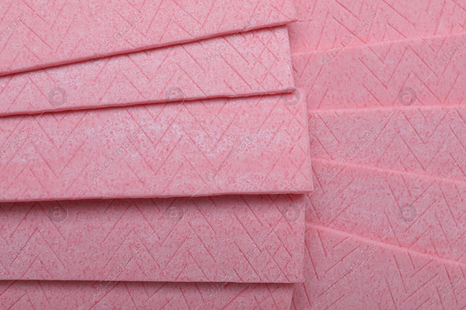 Photo of Sticks of pink chewing gum as background, top view