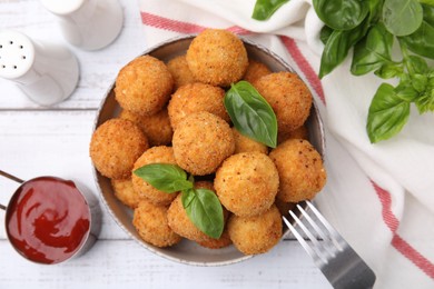 Bowl of delicious fried tofu balls with basil and sauce on white wooden table, flat lay