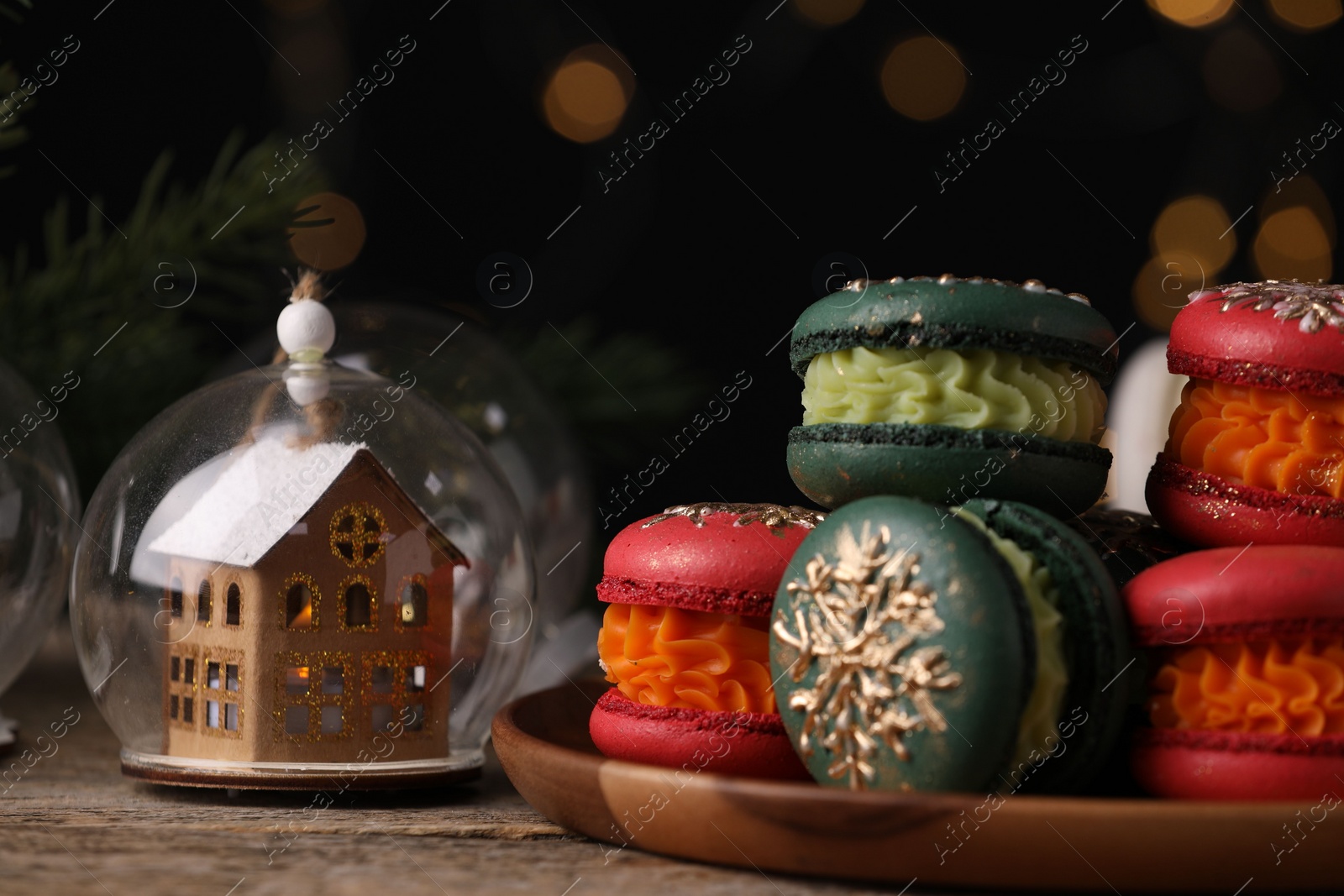 Photo of Beautifully decorated Christmas macarons and festive decor on wooden table, closeup