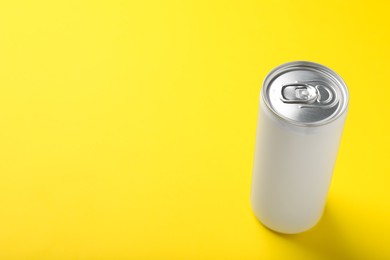 Photo of White can of energy drink on yellow background. Space for text
