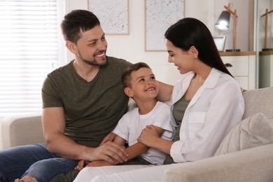 Photo of Happy family on sofa at home. Adoption concept
