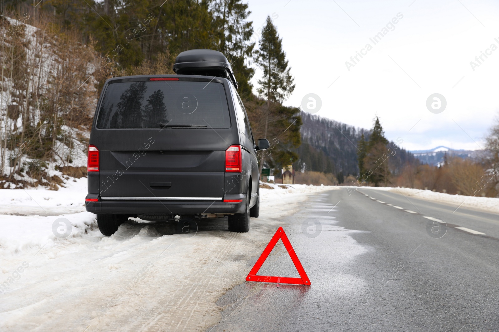 Photo of Emergency stop sign and broken car on winter day