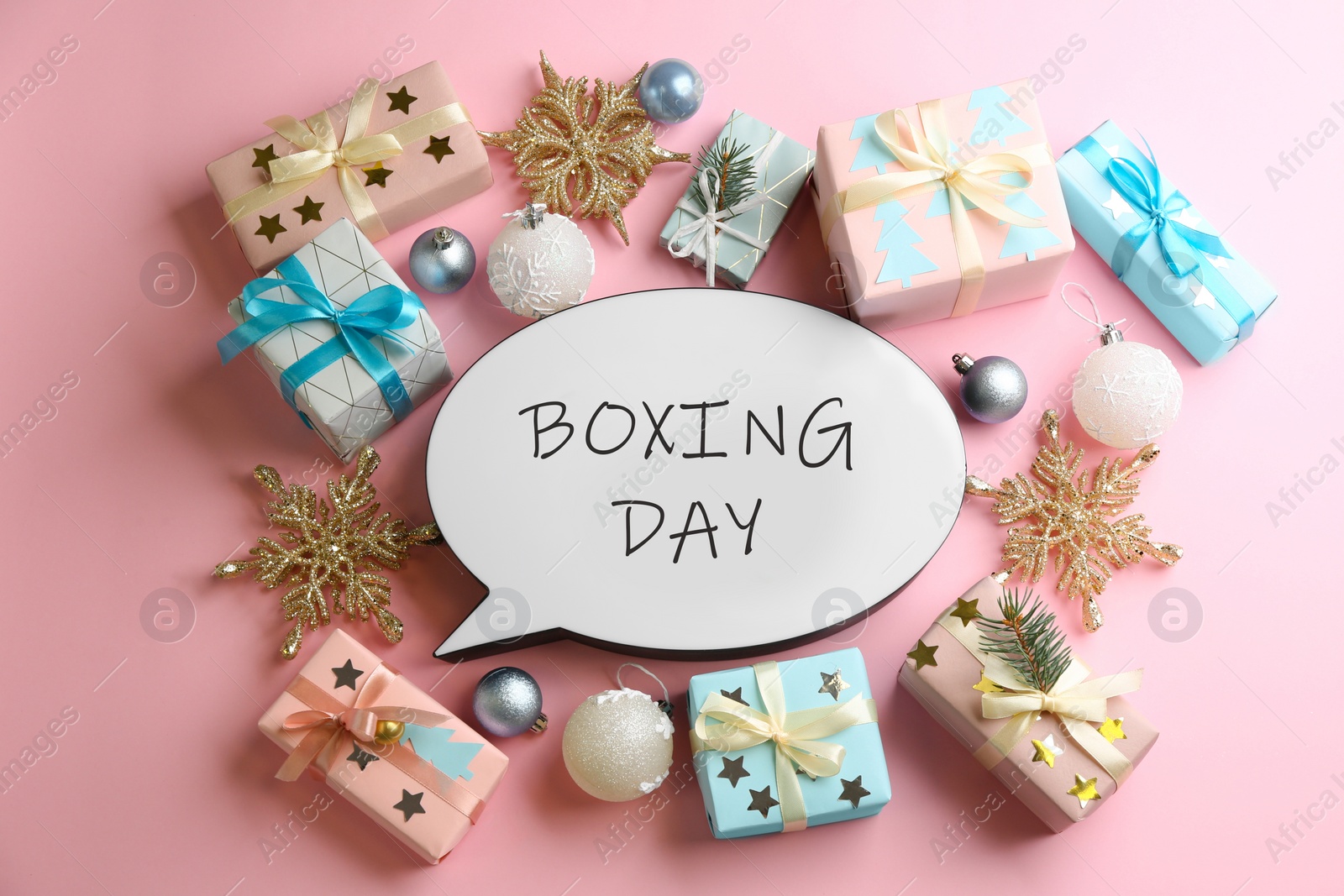 Photo of Speech bubble with phrase BOXING DAY and Christmas decorations on light pink background, flat lay