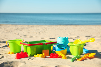 Different child plastic toys on sandy beach. Space for text