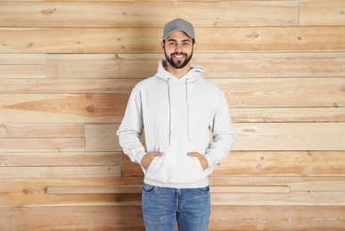 Portrait of young man in sweater at wooden wall. Mock up for design