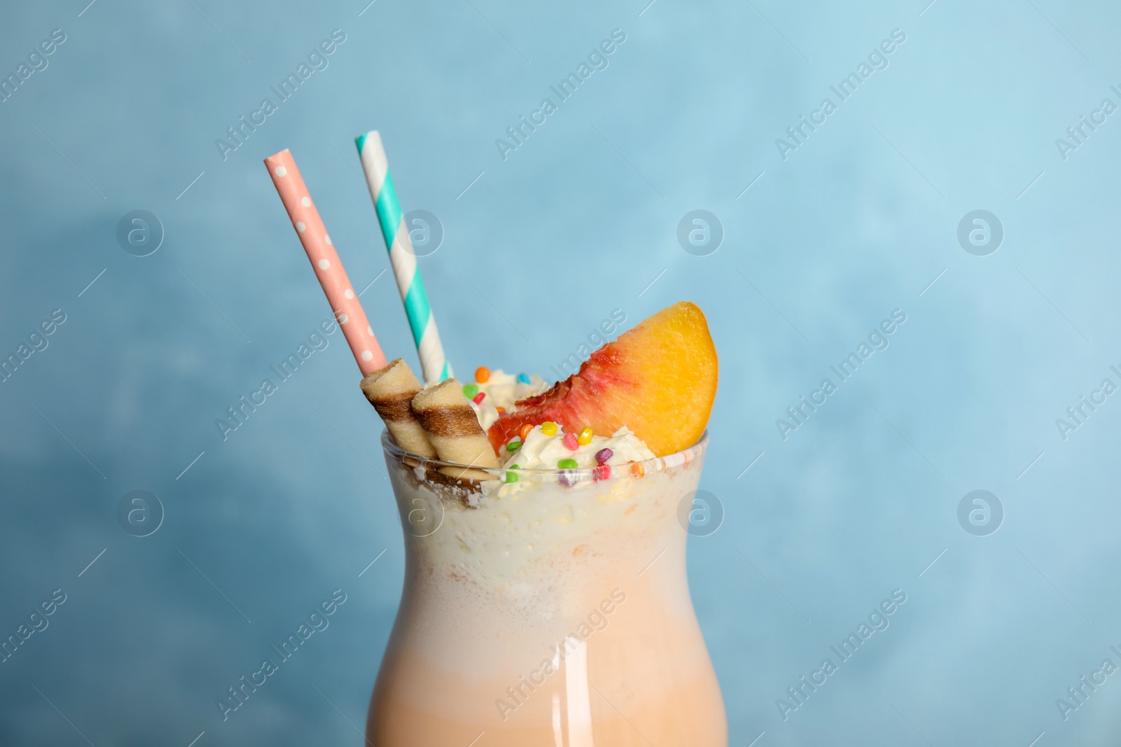 Photo of Glass with delicious milk shake on color background, closeup