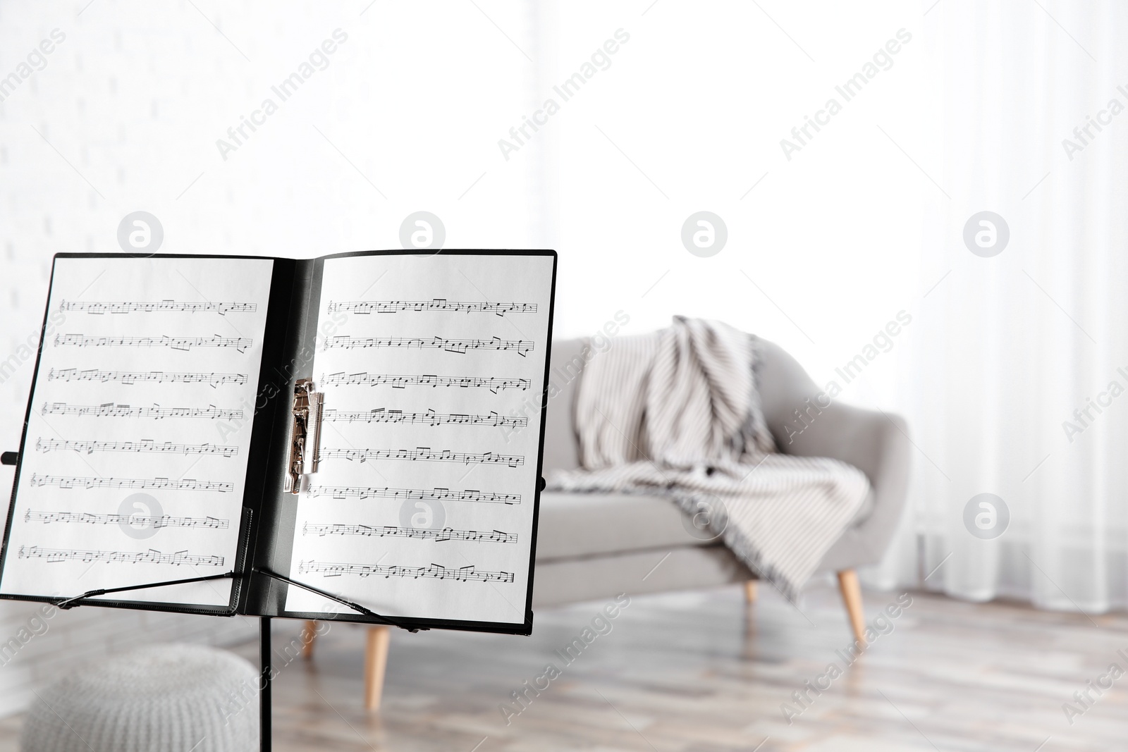 Photo of Note stand with music sheets indoors. Space for text