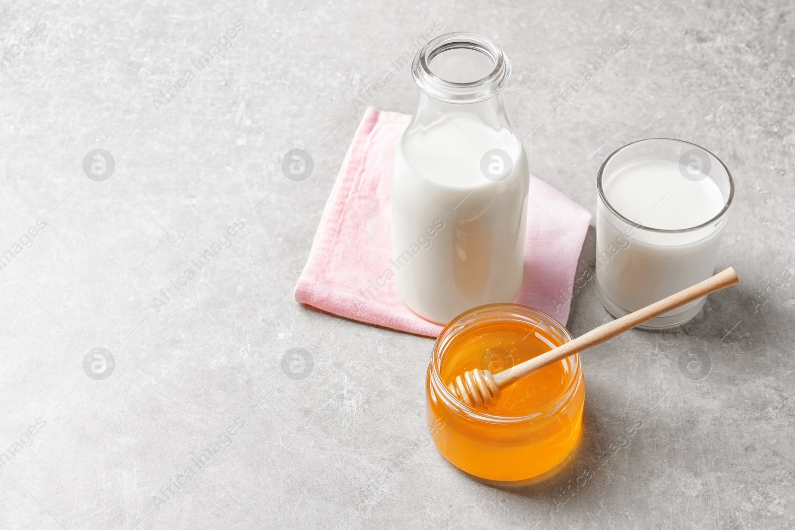 Photo of Beautiful composition with milk and honey on grey background