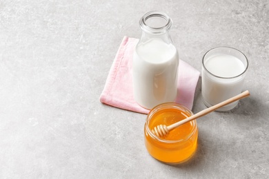 Photo of Beautiful composition with milk and honey on grey background