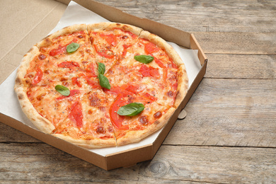 Photo of Hot cheese pizza Margherita on wooden table