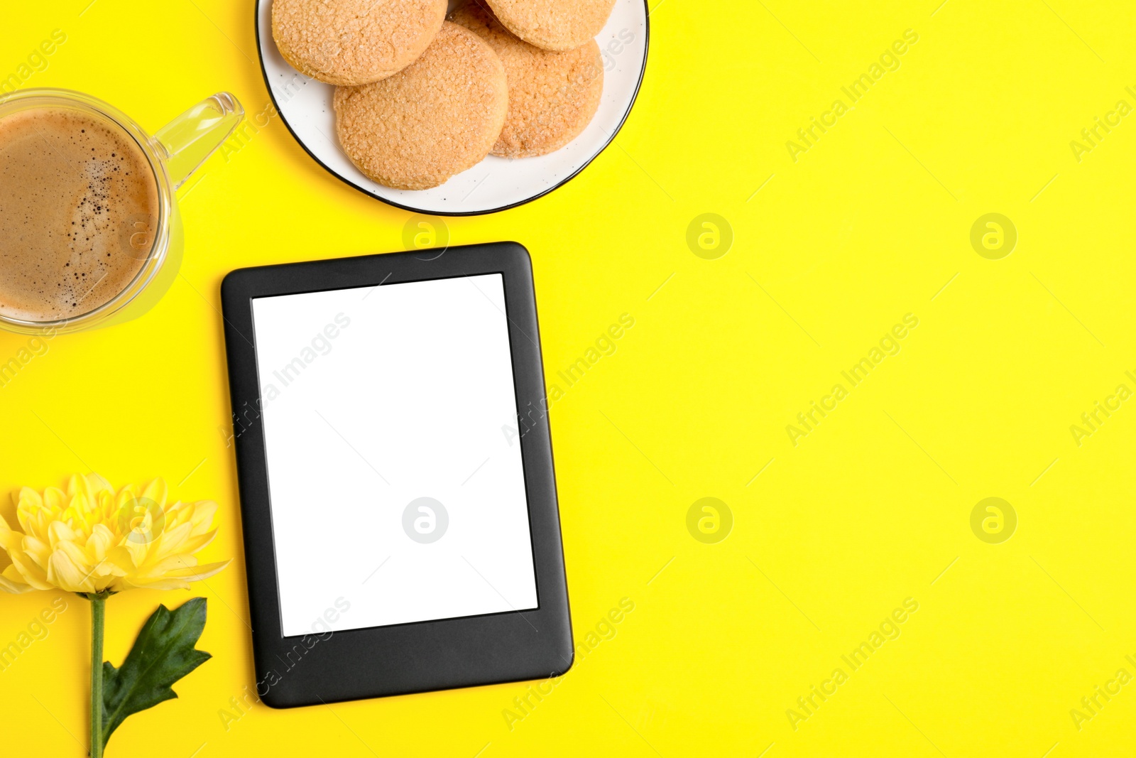 Photo of Flat lay composition with modern e-book reader on yellow background. Space for text
