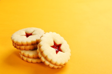 Traditional Christmas Linzer cookies with sweet jam on color background