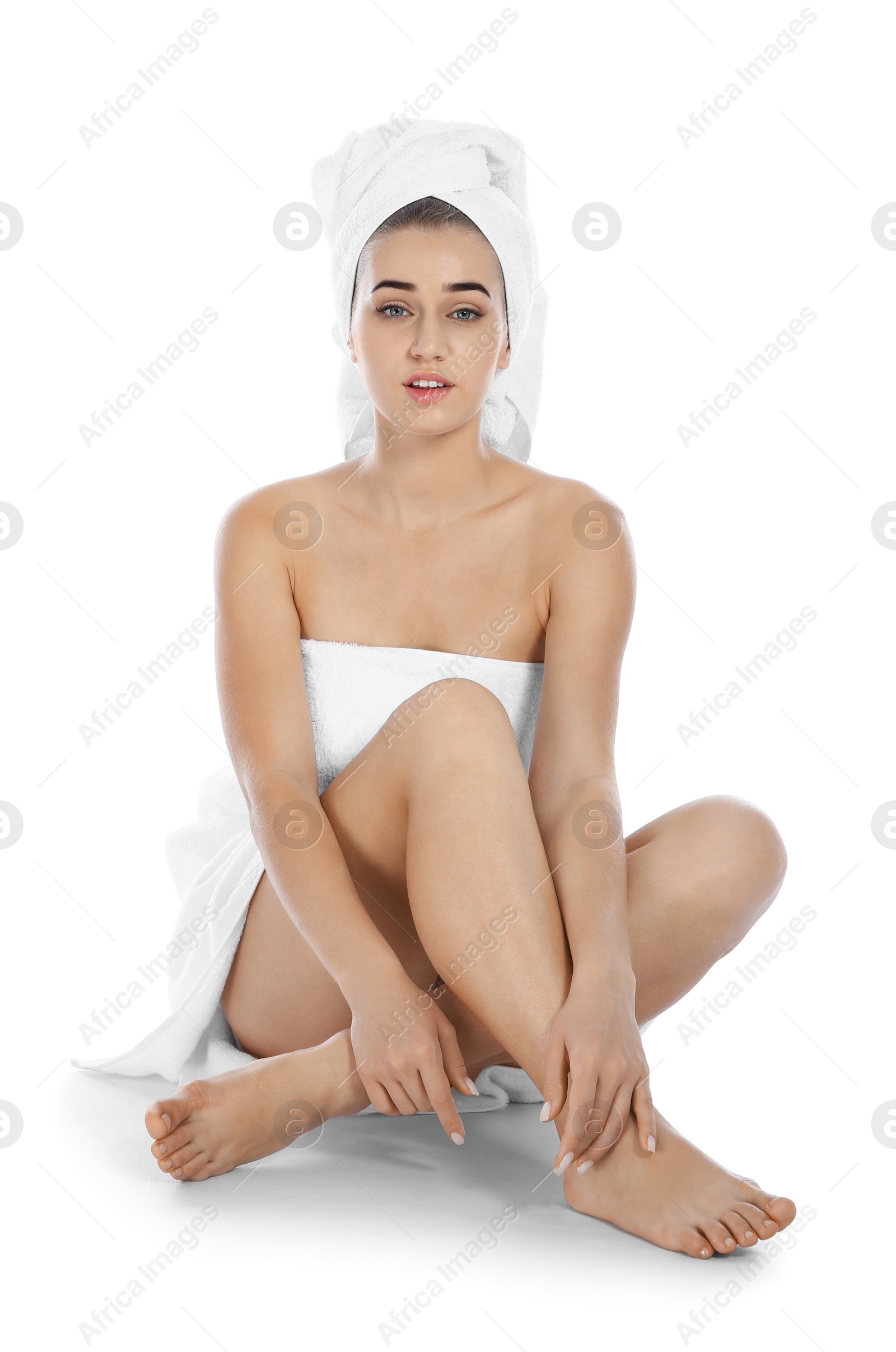 Photo of Portrait of young pretty woman with towels sitting on white background