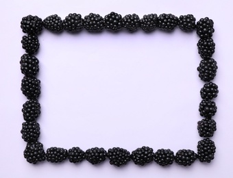 Frame of ripe blackberries on white background, flat lay. Space for text