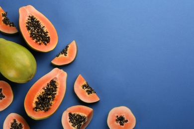 Fresh ripe papaya fruits on blue background, flat lay. Space for text