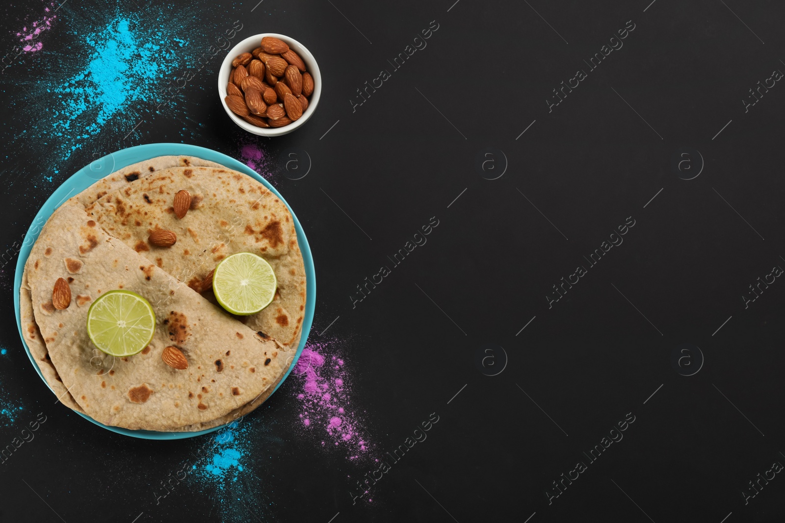 Photo of Traditional Indian food and color powders on black background, flat lay with space for text. Holi festival celebration