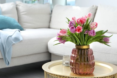 Photo of Beautiful bouquet of colorful tulip flowers on coffee table in room, space for text