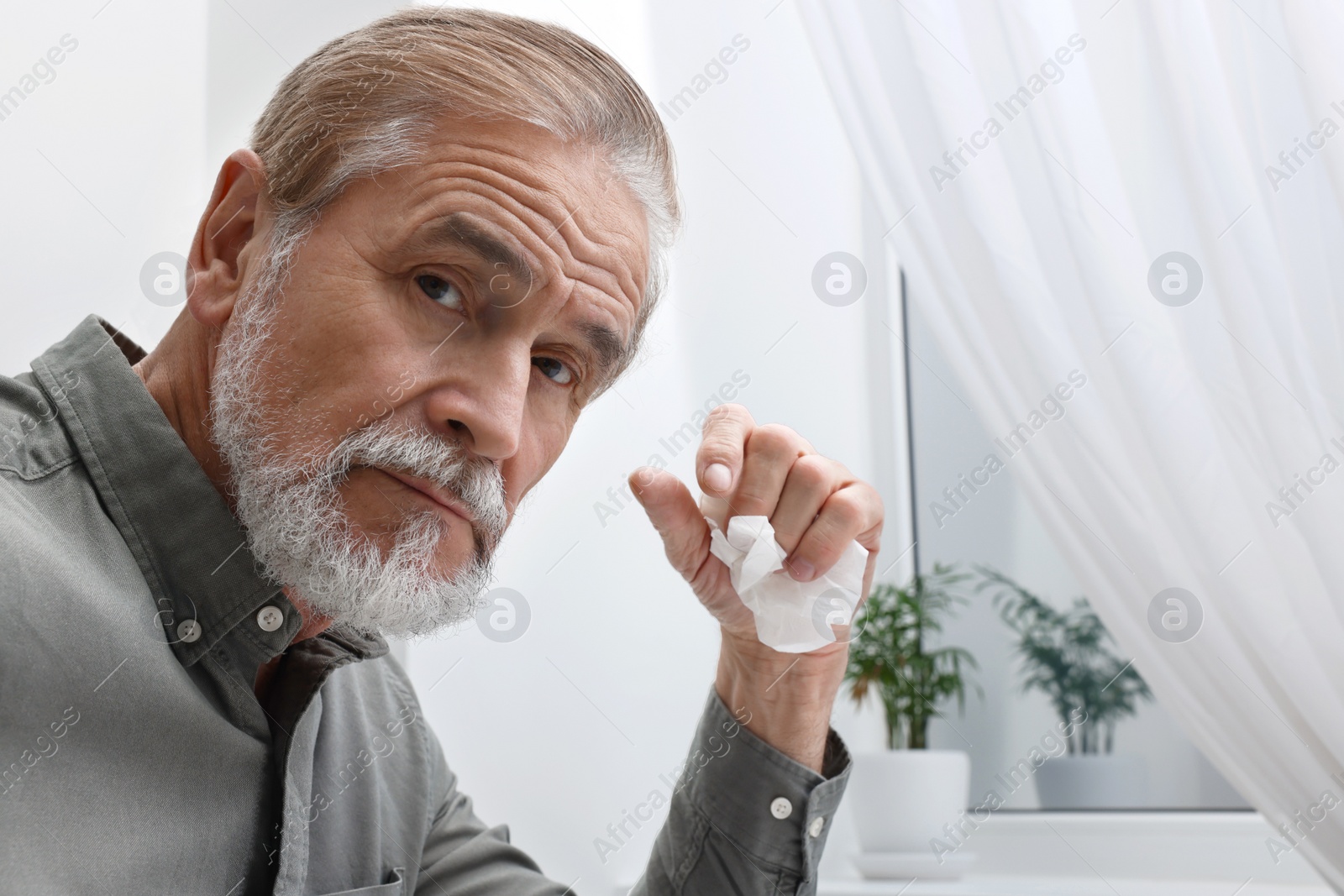 Photo of Upset senior man with napkin at home. Loneliness concept