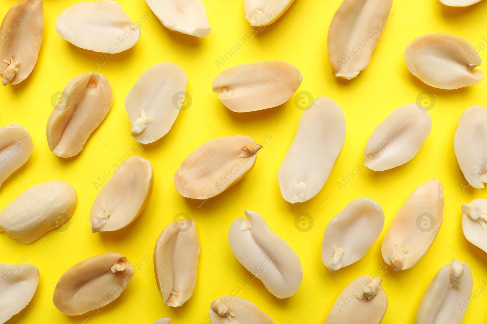 Photo of Fresh peanuts on yellow background, top view