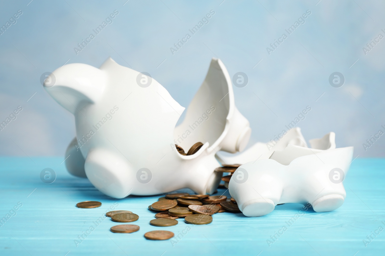 Photo of Broken piggy bank with coins on color table