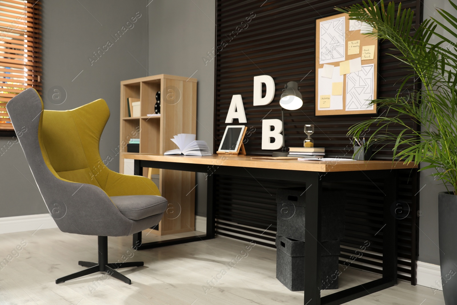 Photo of Comfortable workplace with wooden table and armchair