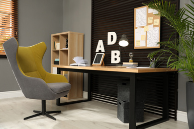 Comfortable workplace with wooden table and armchair