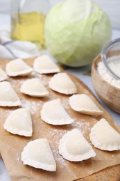 Photo of Raw dumplings (varenyky) with tasty filling and ingredients on light grey table