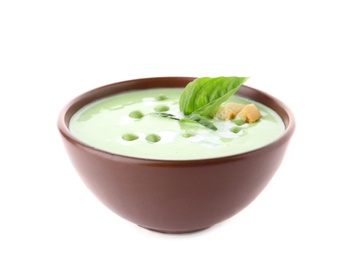 Photo of Green pea soup with croutons in bowl on white background