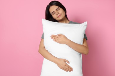 Photo of Sleepy young woman with soft pillow on pink background