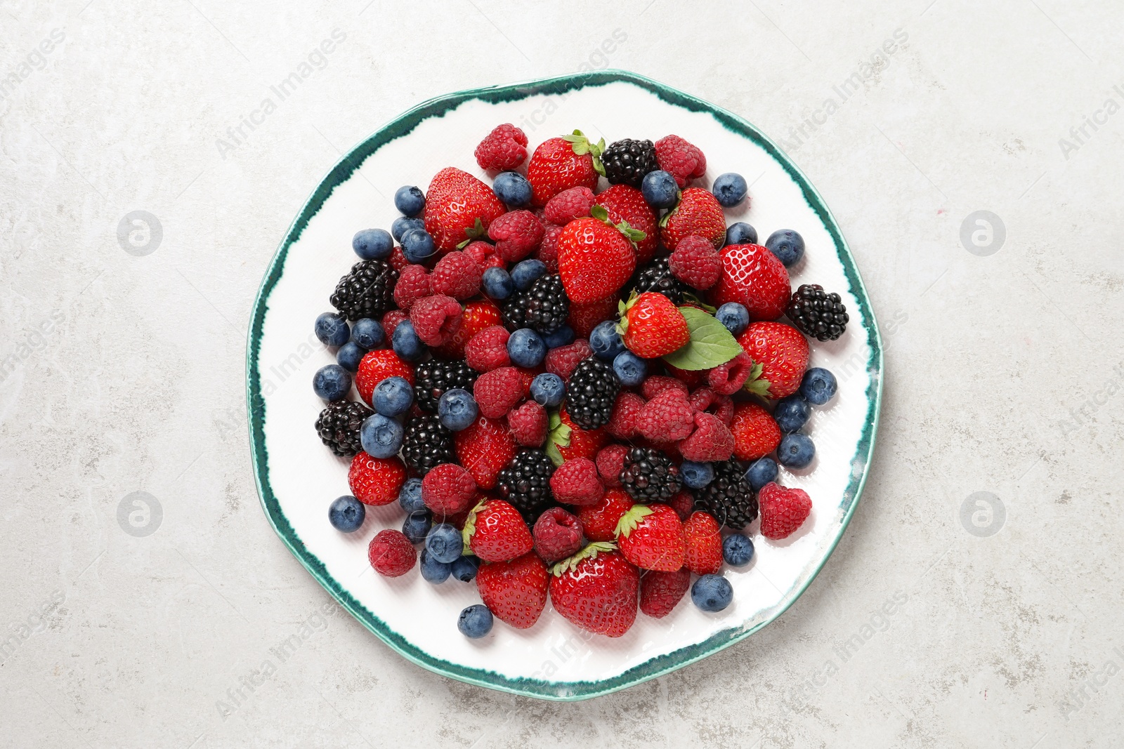 Photo of Different fresh ripe berries on light grey table, top view