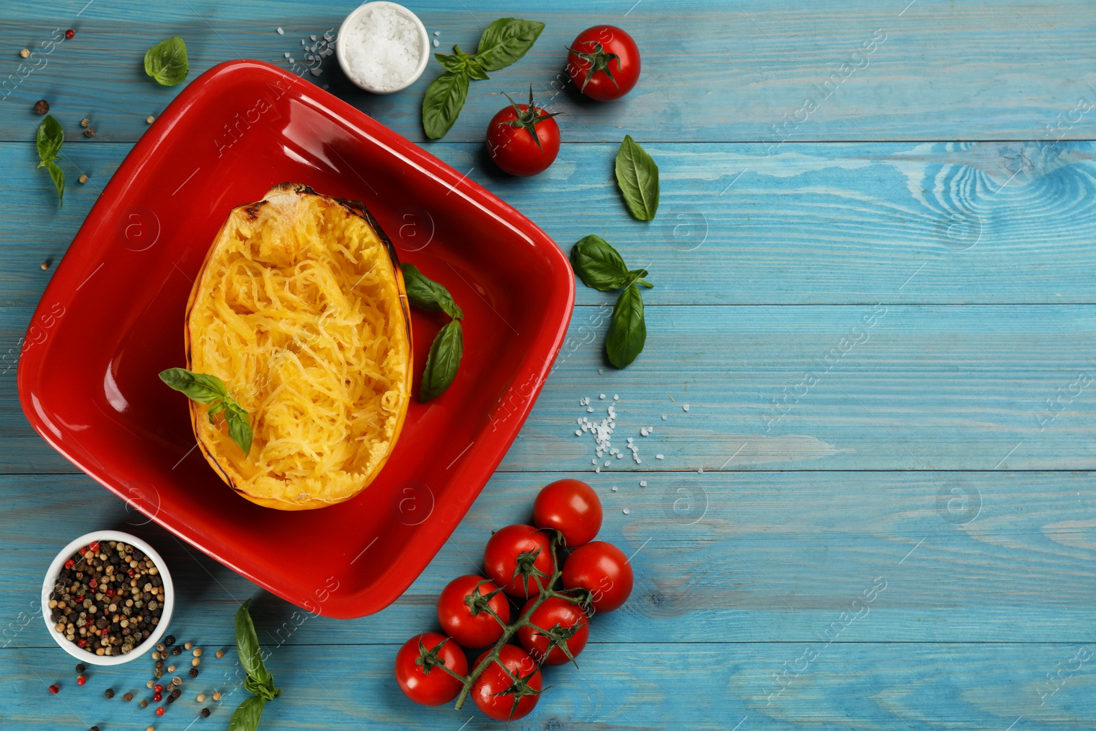 Photo of Half of cooked spaghetti squash in baking dish and ingredients on turquoise wooden table, flat lay. Space for text