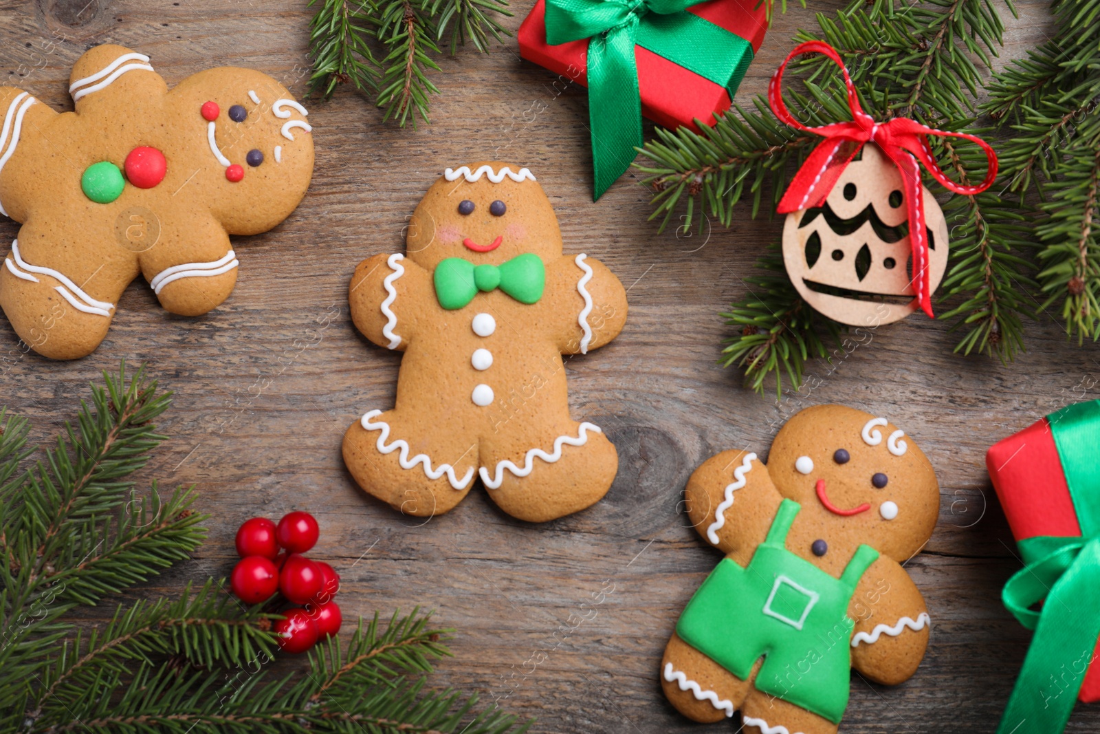 Photo of Flat lay composition with gingerbread men on wooden table