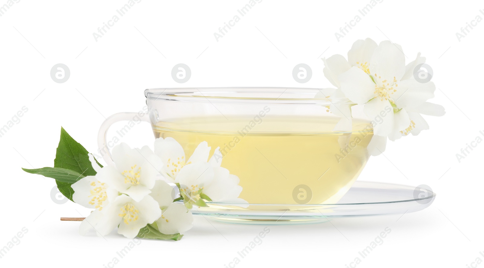 Photo of Aromatic herbal tea in glass cup, teapot and flowers isolated on white