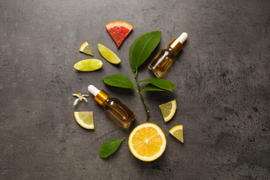 Photo of Flat lay composition with bottles of citrus essential oil on grey background