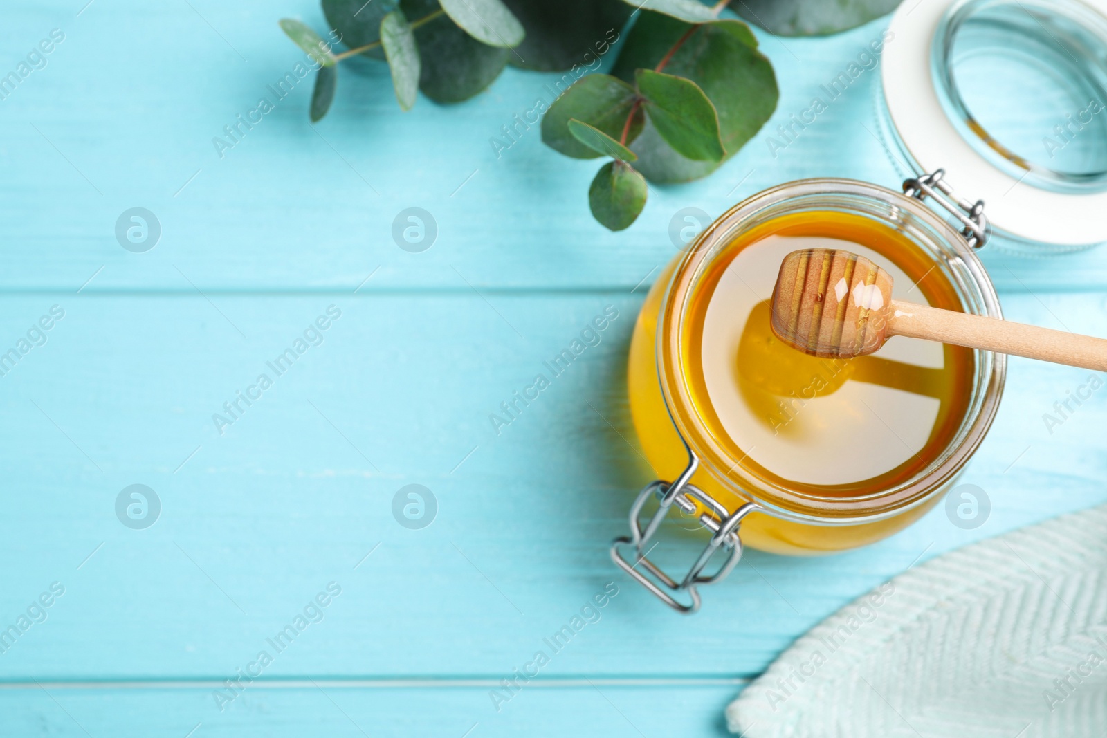 Photo of Flat lay composition with fresh honey on light blue wooden table. Space for text